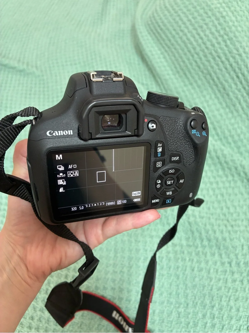Canon DSLR Camera Body in Black with Red Strap Accents and kit lens.